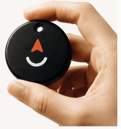 A hand holding the round black Launchpad